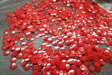 a pile of red plastic resin beads on a table