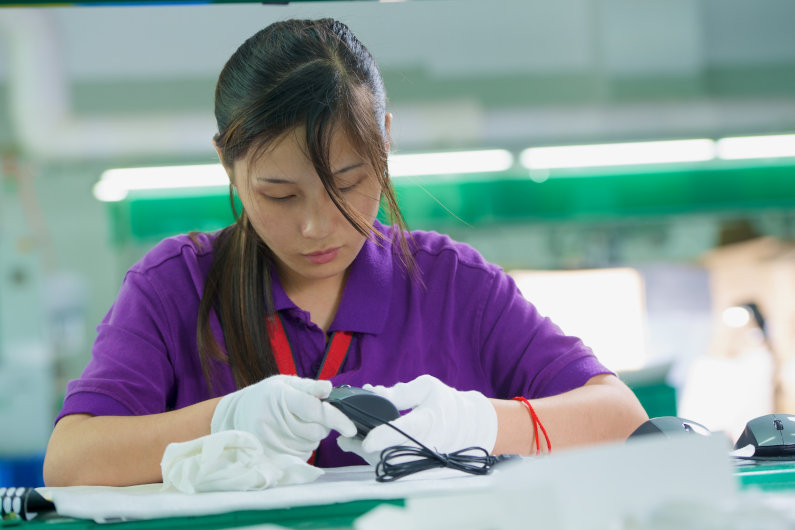 Woman at Chinese manufacturer assembling computer mouse