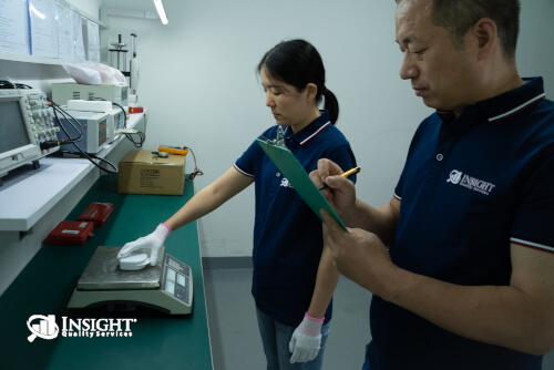 Inspectors weighing product and recording on checklist