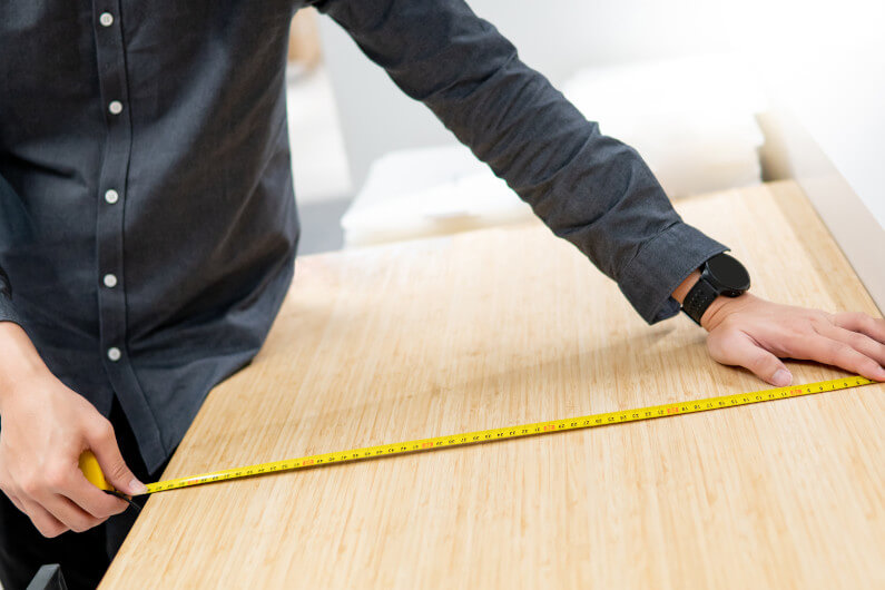 Man measuring the surface of a table