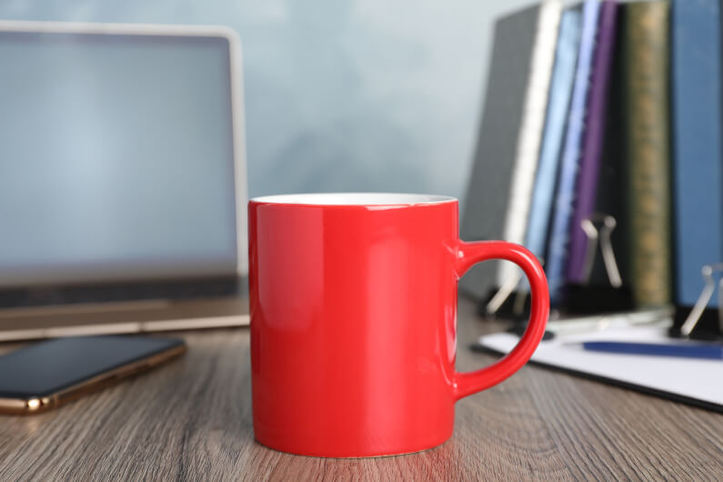 Red mug on golden desk that doesn't match golden sample