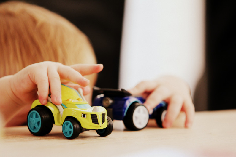 Child playing with toy cars