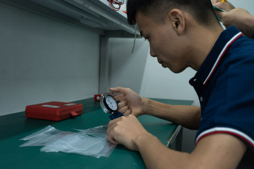 Inspector checking the thickness of a plastic bag