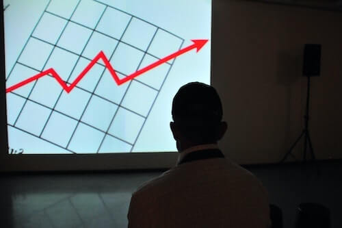 Man looking at graph of increasing profits