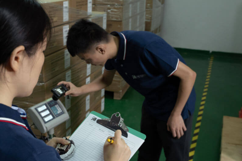 Inspectors weighing cartons for inspection