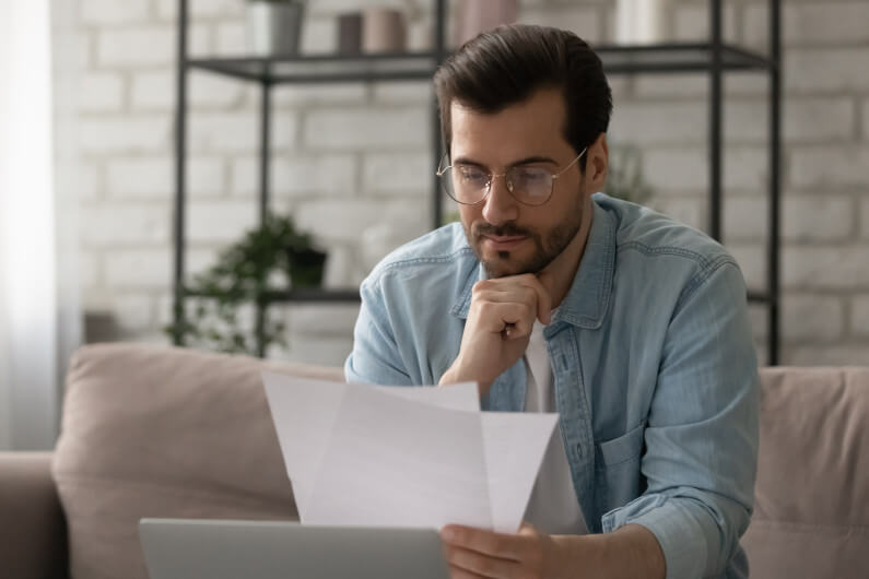 Man reading document, holding paper