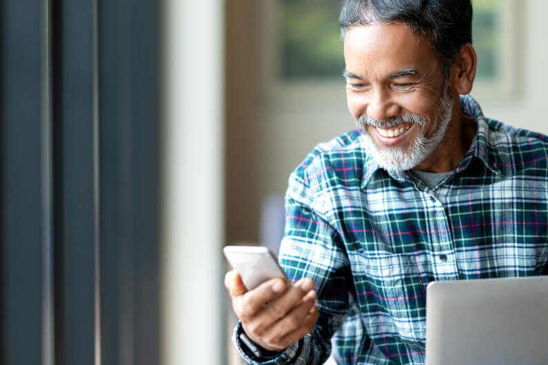 Man looking at cell phone and smiling