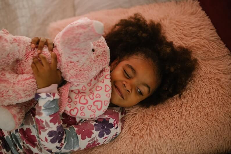 Child in pajamas with stuffed toy