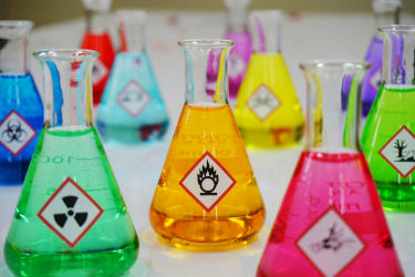 Various colorful chemicals inside Erlenmeyer flasks