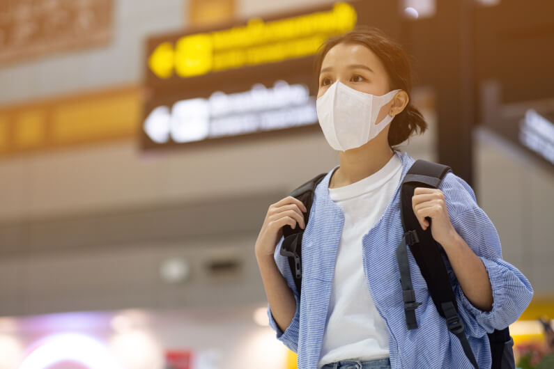 Woman traveling in airport with facemask
