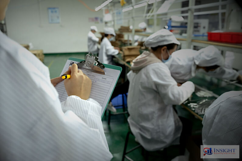 Insight auditor inside a factory holding a clipboard